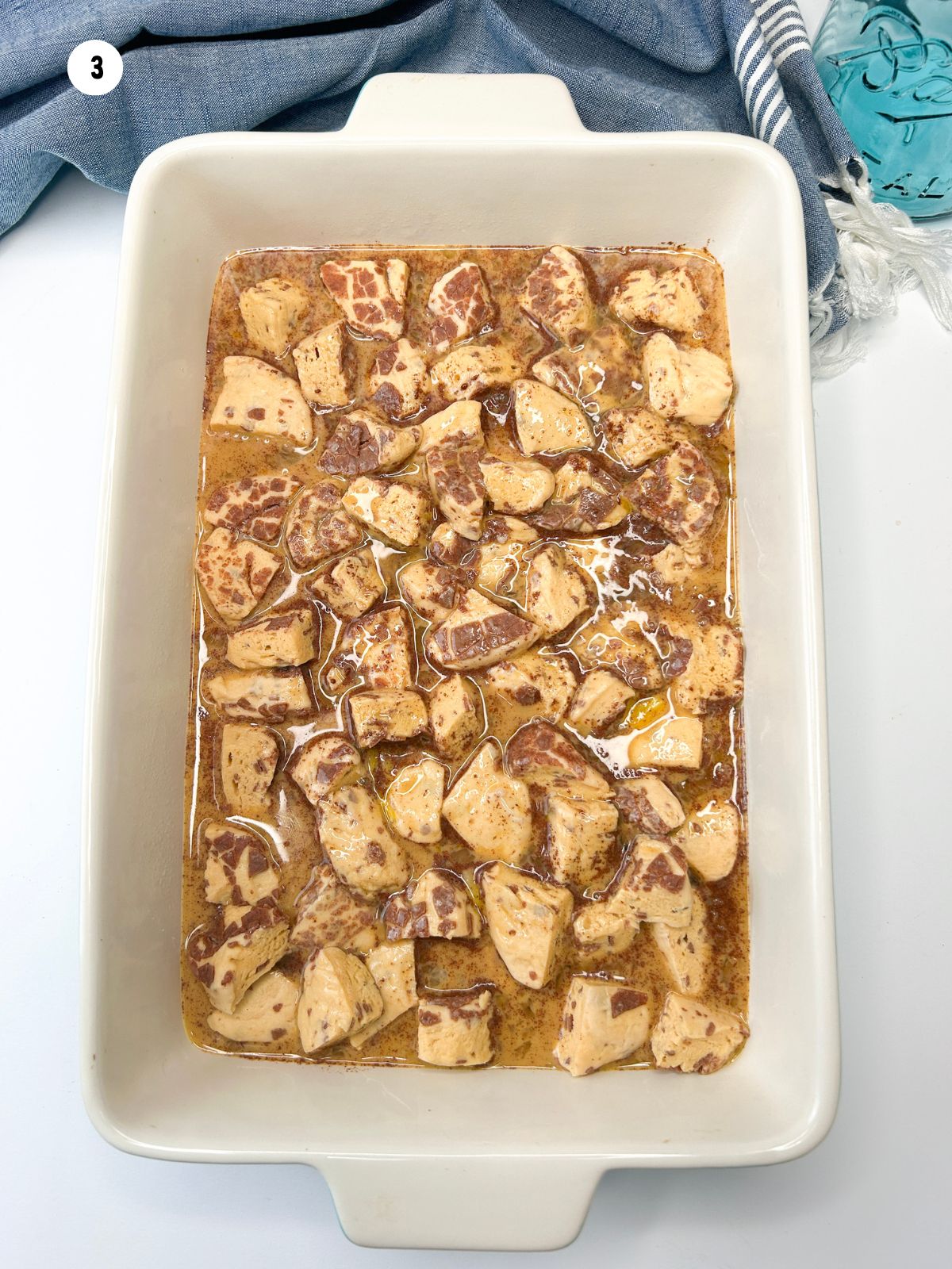 egg mixture on top of cut up pieces of cinnamon rolls in casserole dish.