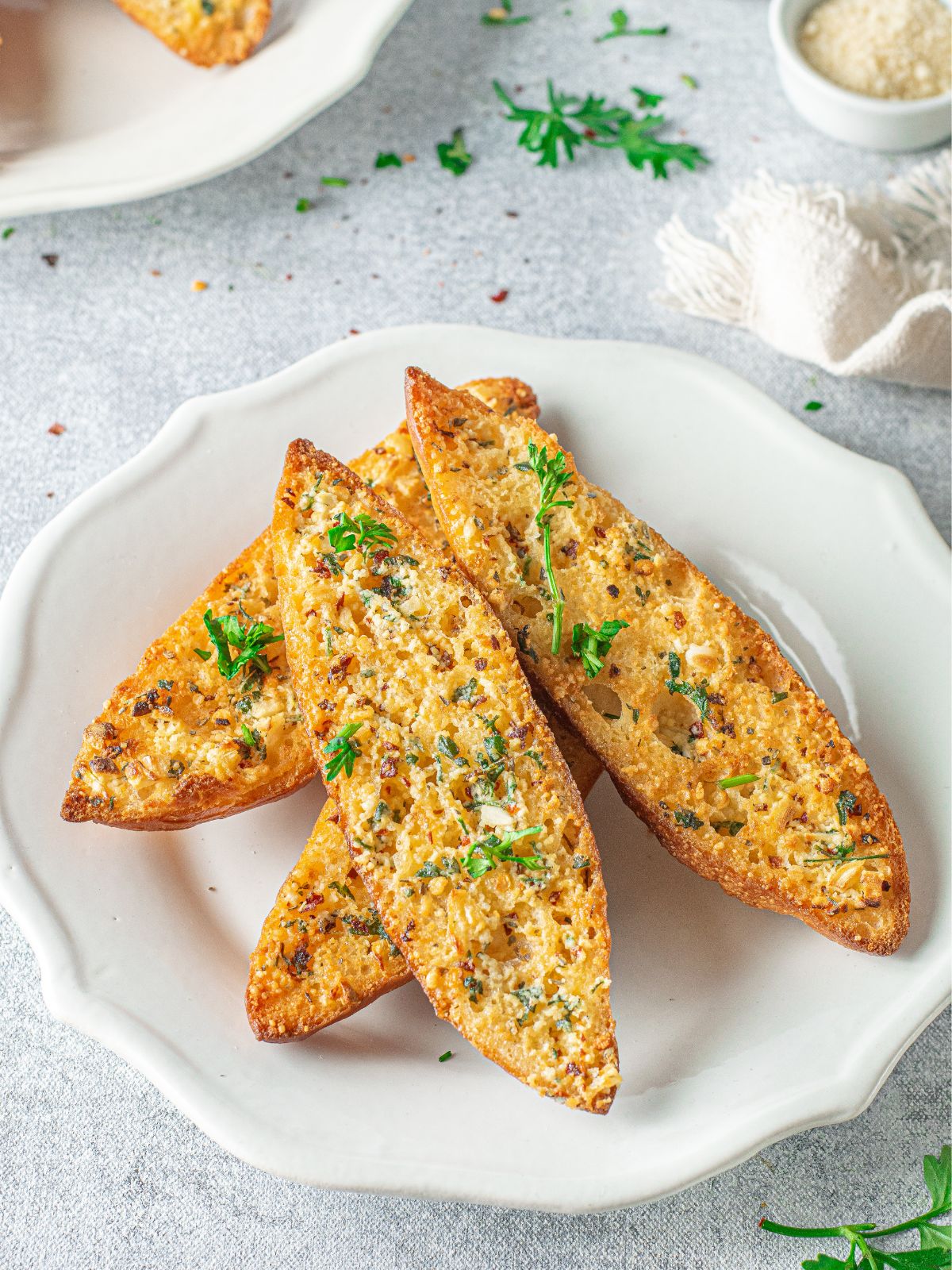 Garlic bread served on a white plate.