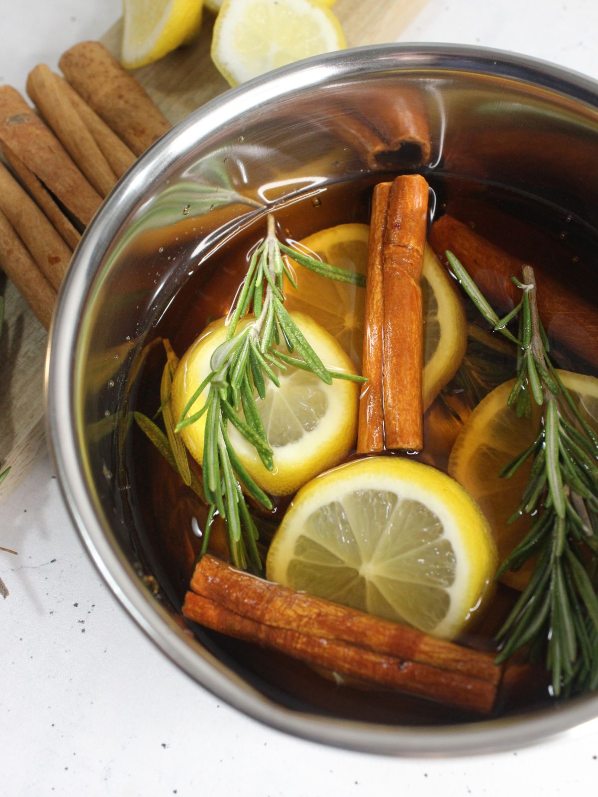 Close up view of the lemons, cinnamon sticks and sprigs of rosemary.