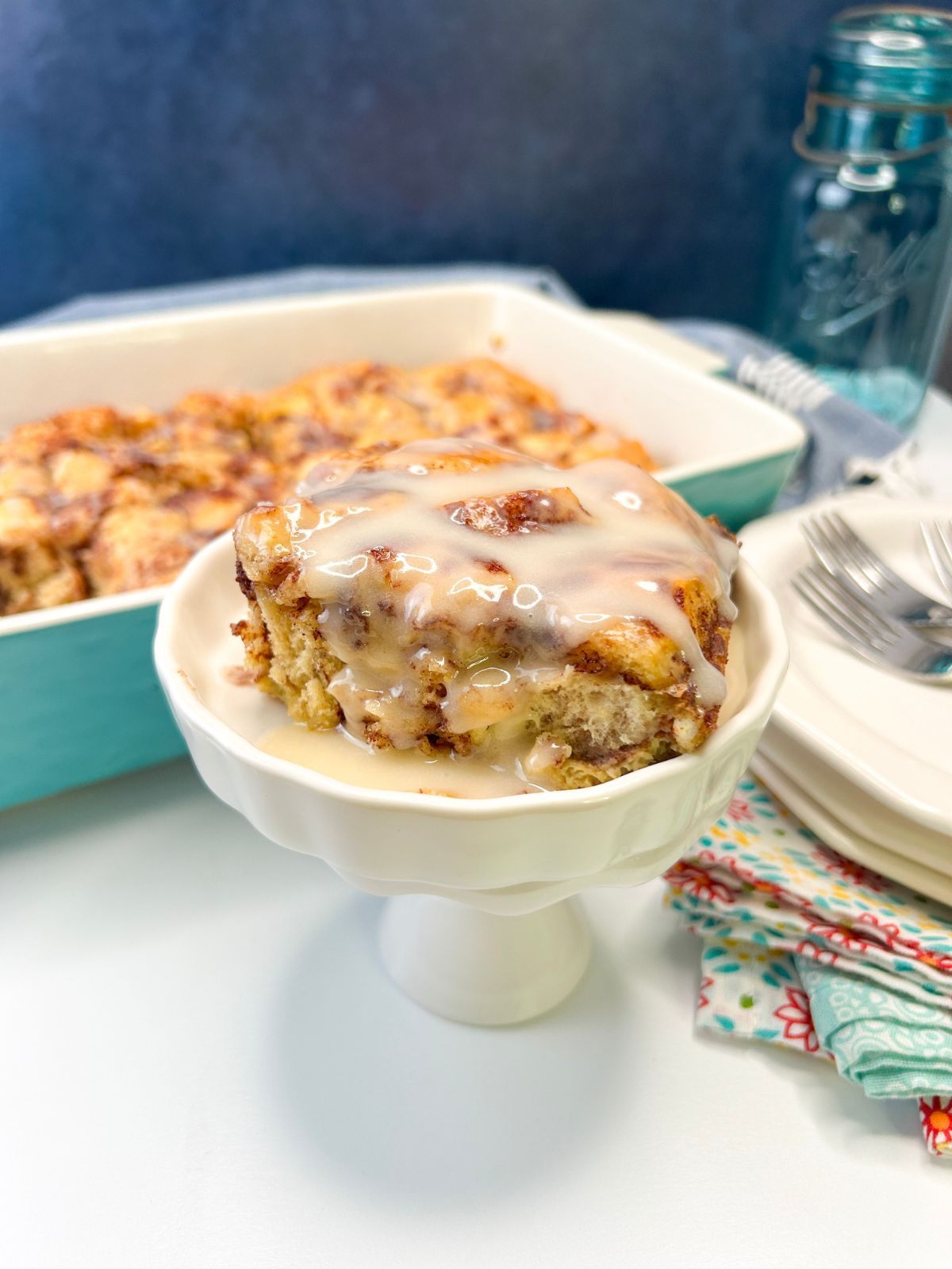 How to Make an Easy Cinnamon Roll Breakfast Casserole from Walking on Sunshine Recipes baked casserole made with Pillsbury cinnamon rolls with frosting served in small dish.
