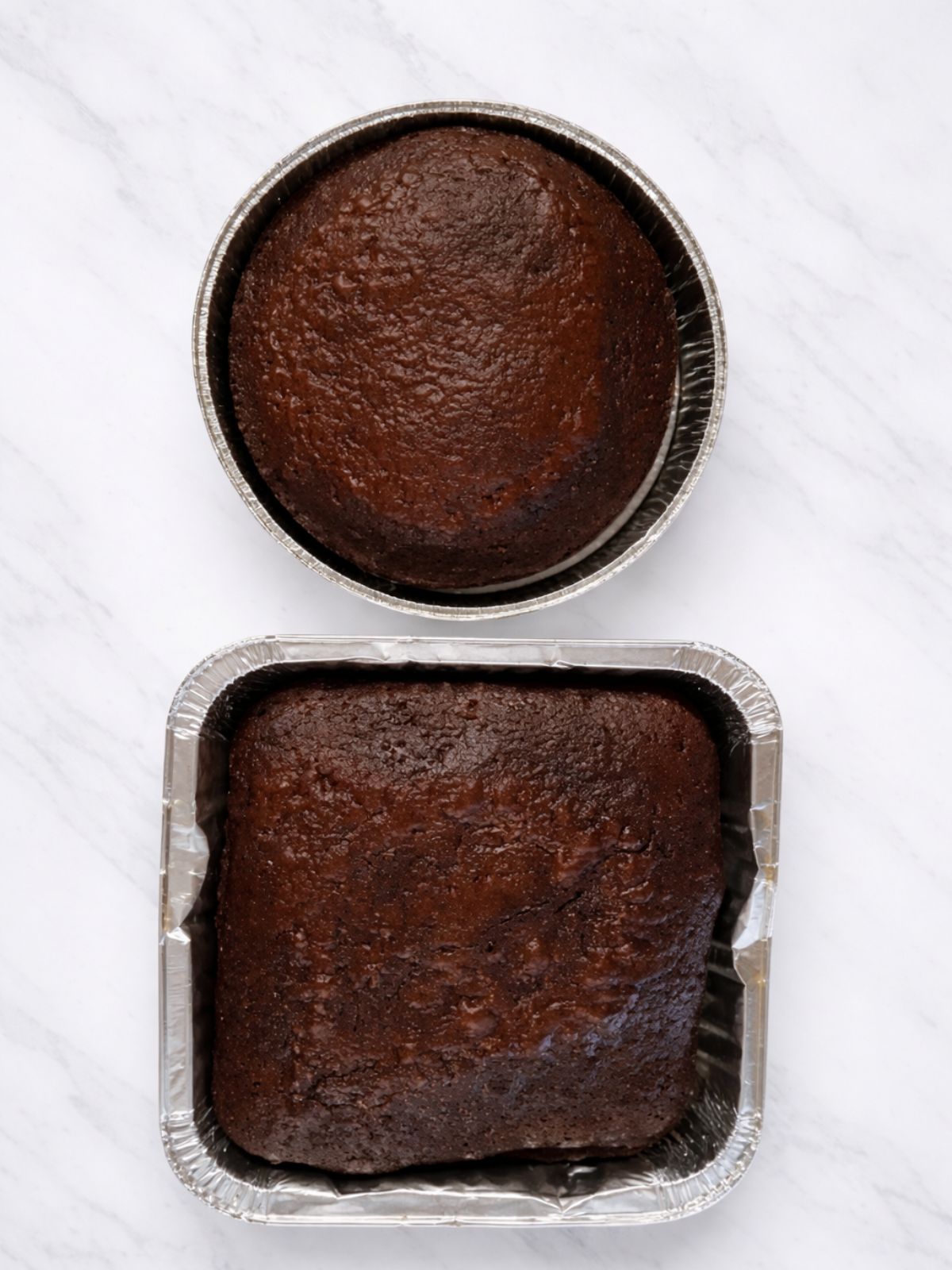 chocolate cake baked in a round cake pan and a square cake pan.