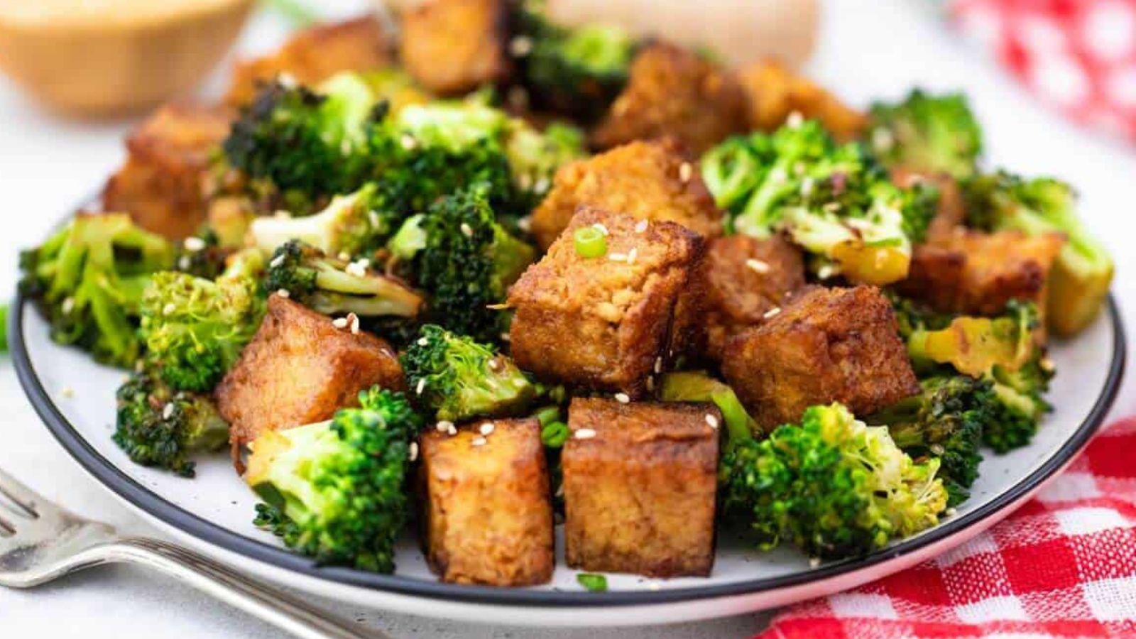 Tofu and broccoli on a plate.