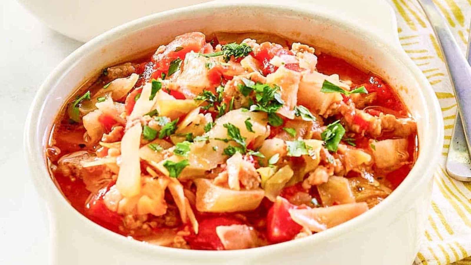 A bowl of cabbage and sausage soup.