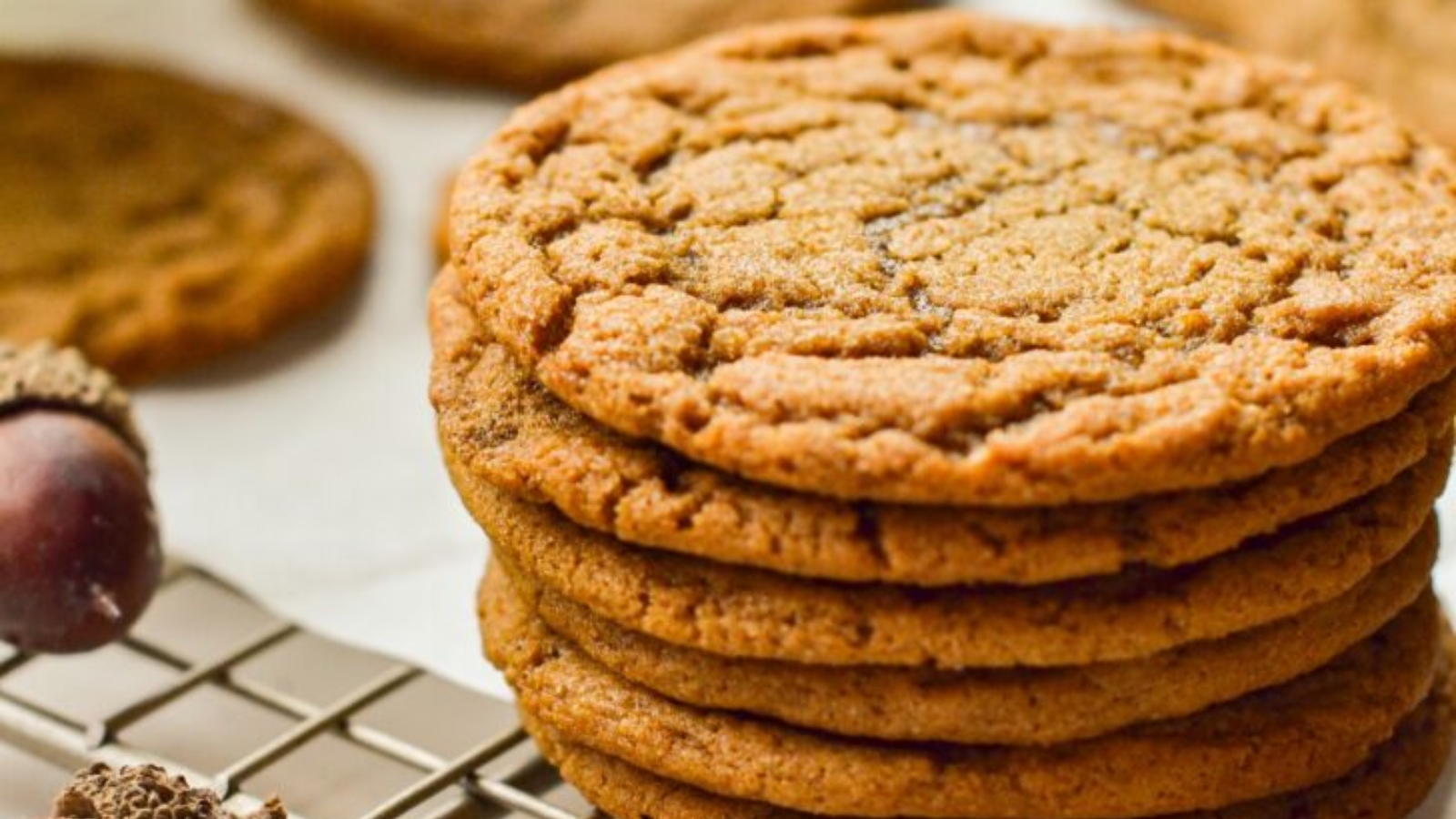 A stack of chewy molasses cookies with crackled tops dusted lightly with sugar.