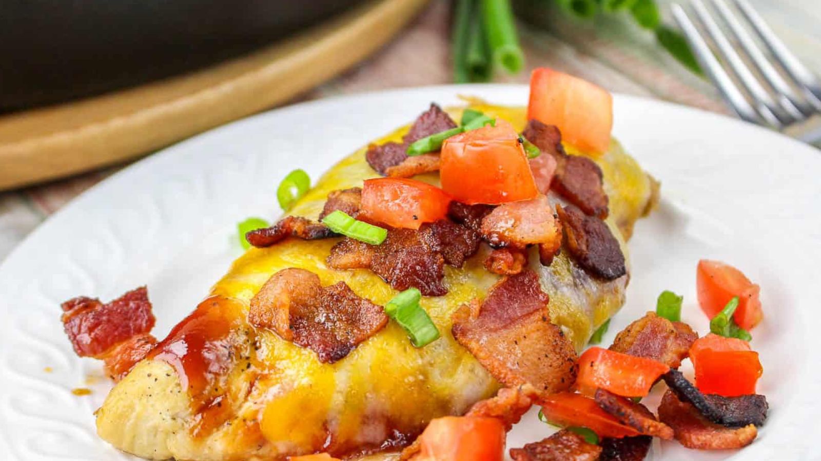 Cheese covered chicken in a skillet with a spatula.