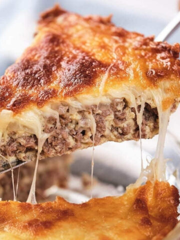 A slice of cheeseburger pie being lifted, showing layers of meat and melted cheese.