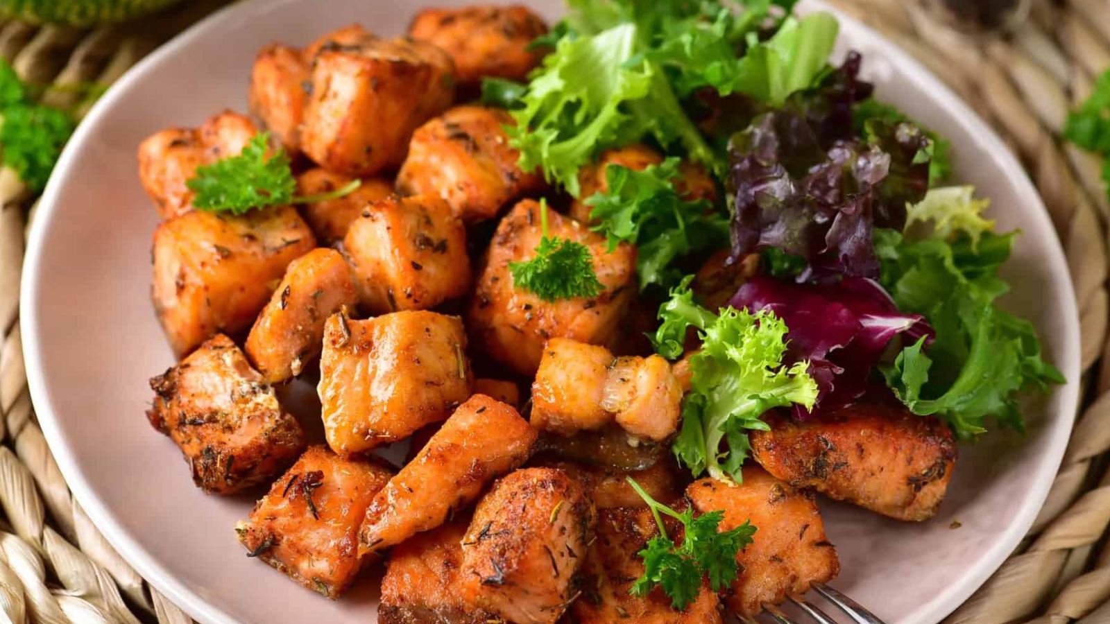 Air Fryer Salmon Bites and a salad on a plate with a fork.