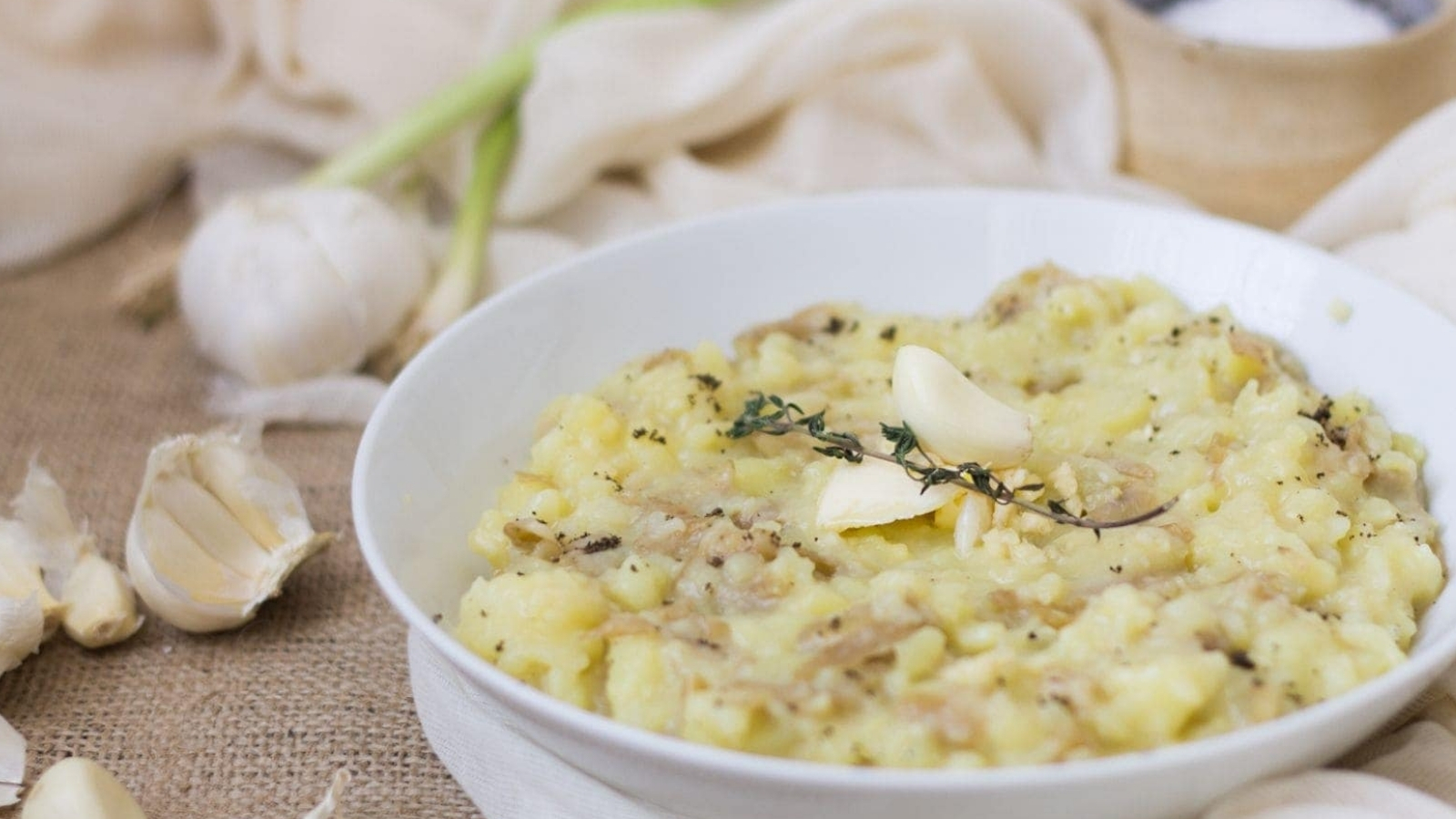 A bowl of mashed potatoes with garlic and thyme.
