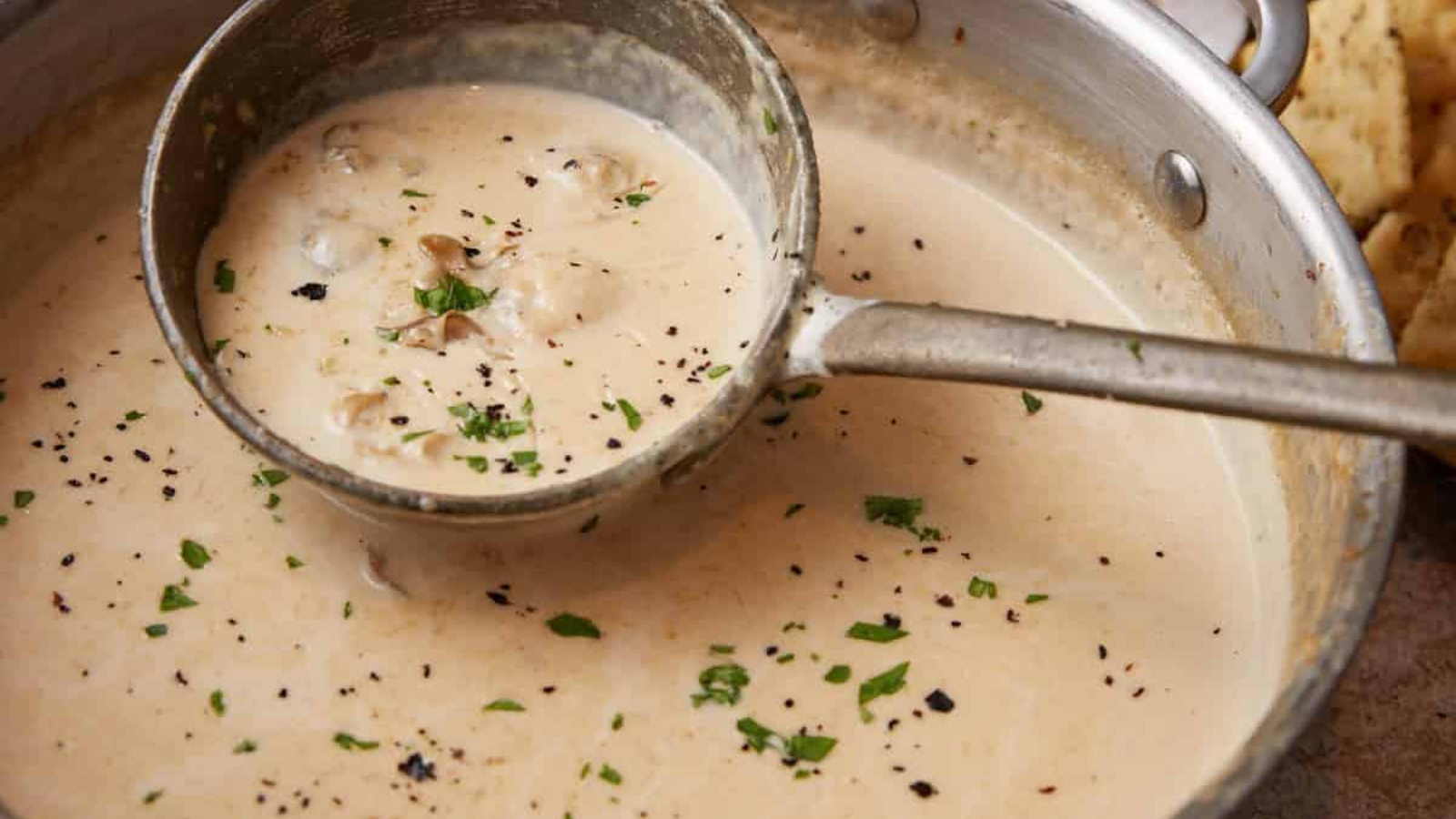 Oyster stew in a pot, ladled.