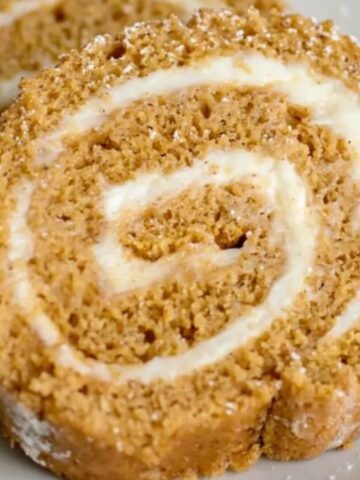 Slices of pumpkin roll served on a white platter.