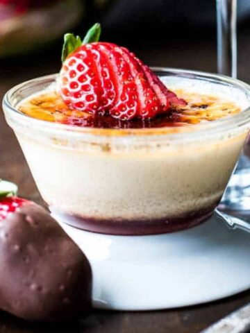 Strawberry crème brûlée with caramelized sugar crust and fresh berries.