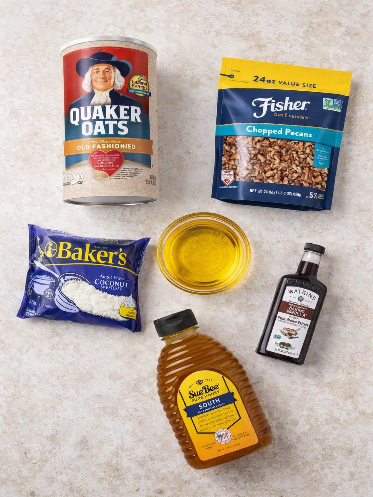 Flat lay of ingredients for homemade Christmas granola gift, including oats, pecans, coconut, honey, oil, and vanilla.