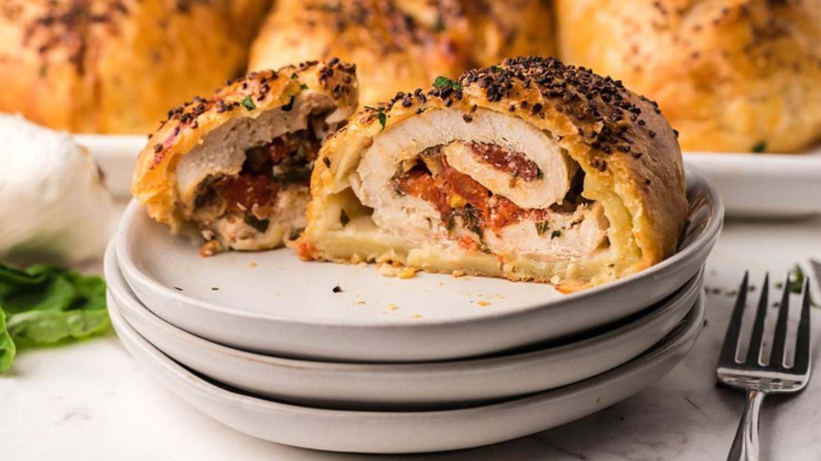 Air fryer bruschetta stuffed chicken breast sliced open on a plate, revealing a filling of tomatoes, herbs, and melted cheese.