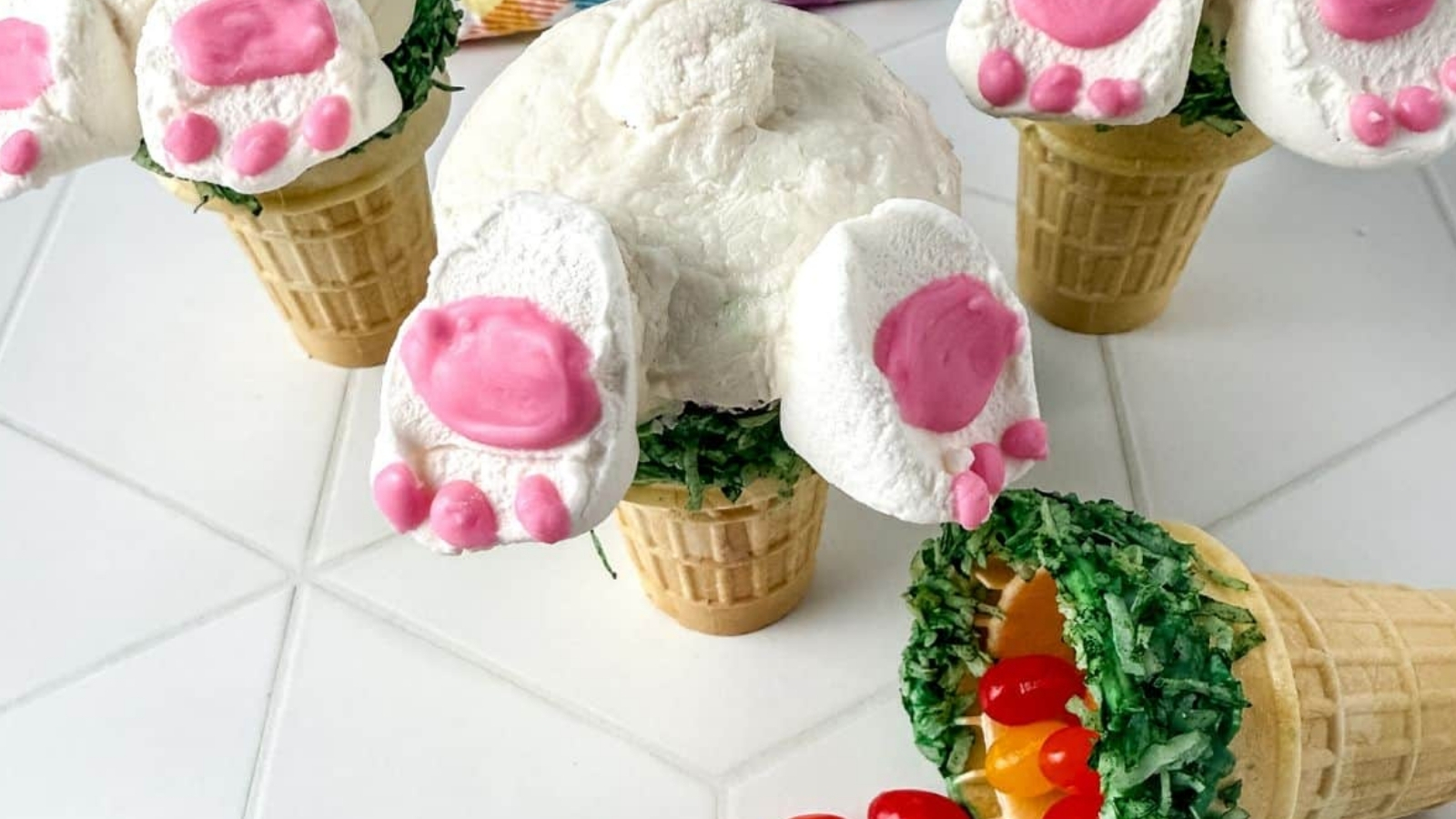 Image of 3 bunny butt cupcakes with jelly beans on counter.