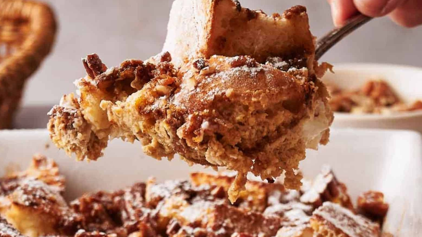 A person taking a portion of French toast casserole.