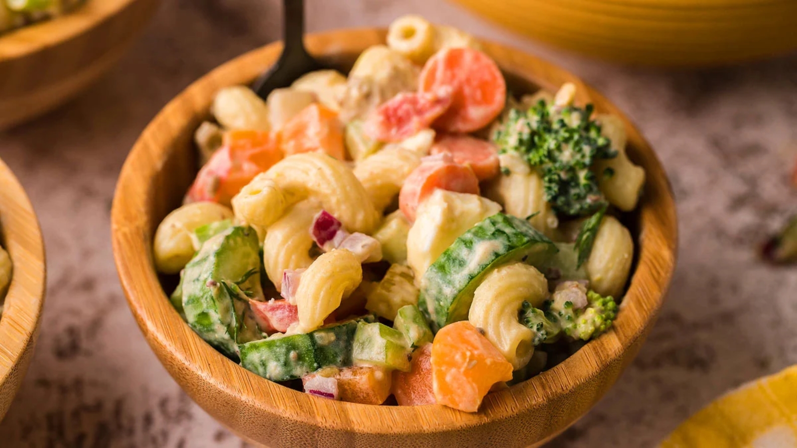 A bowl or macaroni and vegetable salad.