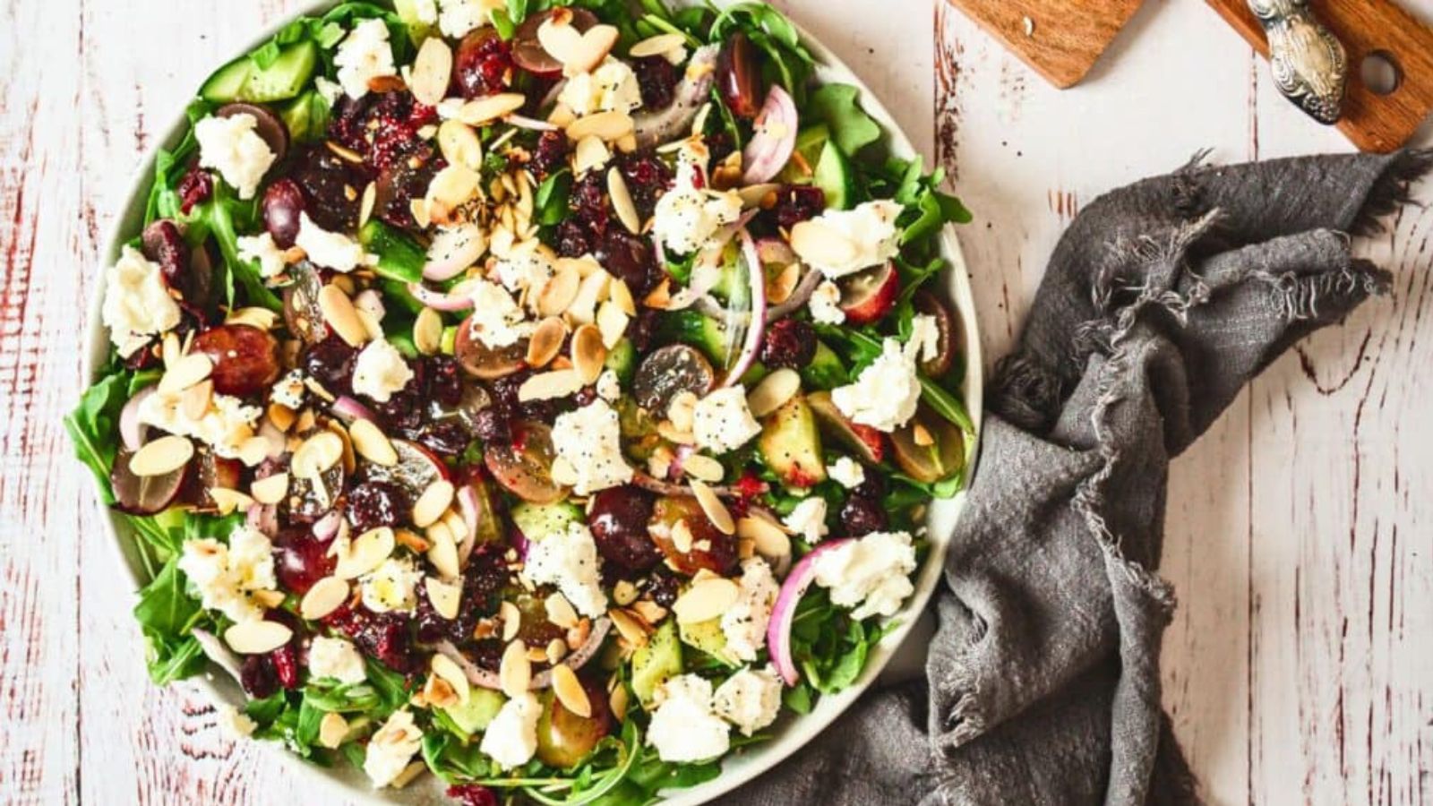 Goat cheese salad with greens, roasted beets, and candied walnuts on a plate.