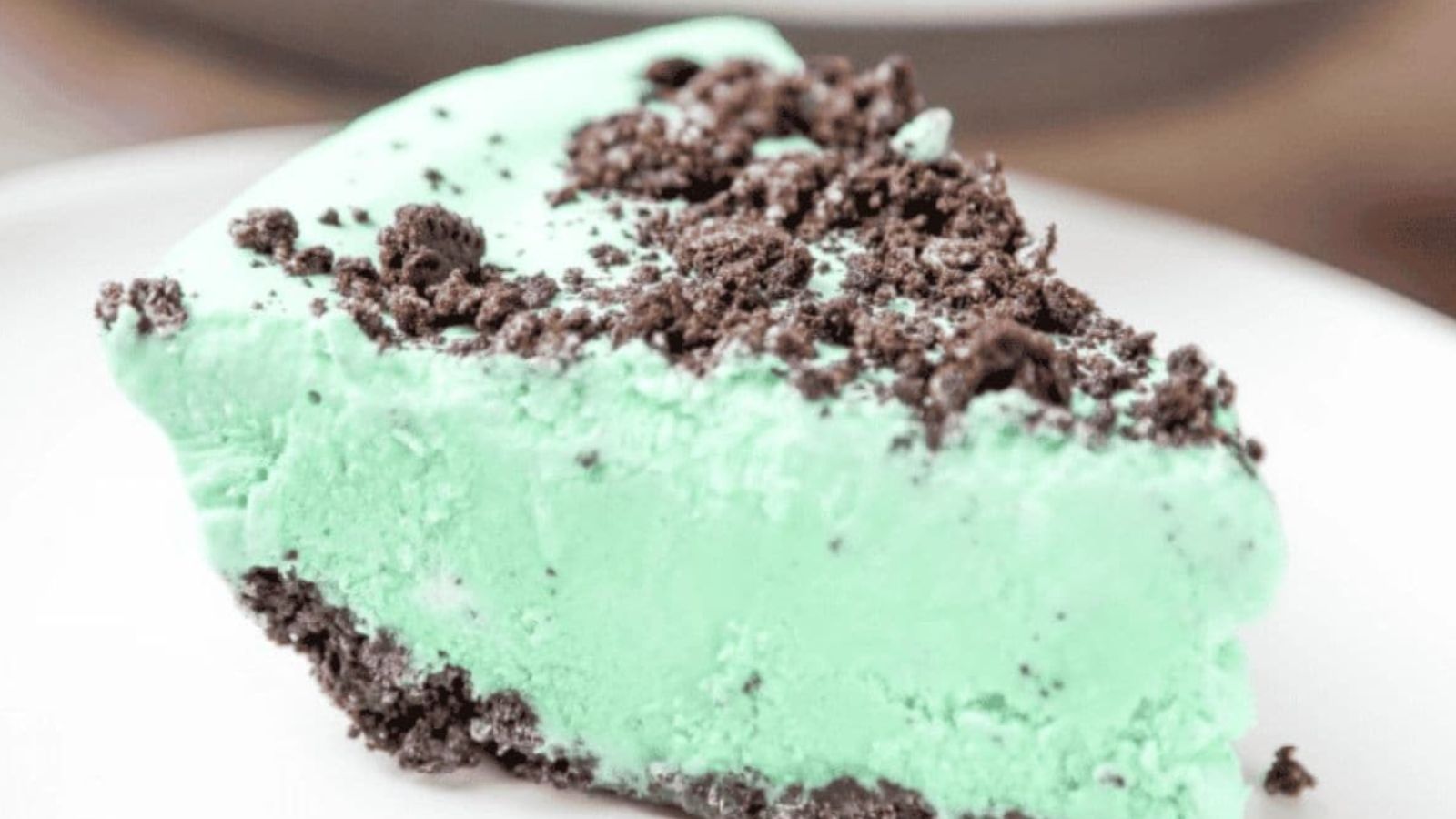 A mint pie inside an oreo crust topped with oreo crumbs.