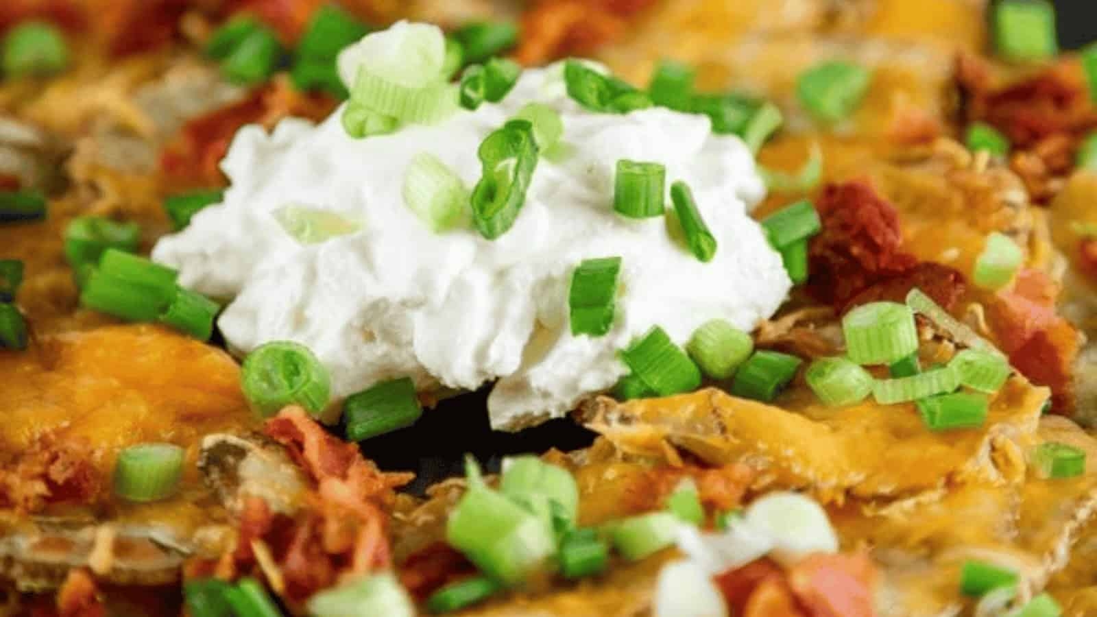 Potato rounds topped with cheese, bacon, sour cream, and green onions.