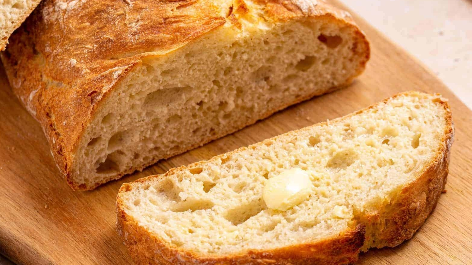 Italian artisan bread sliced on cutting board.