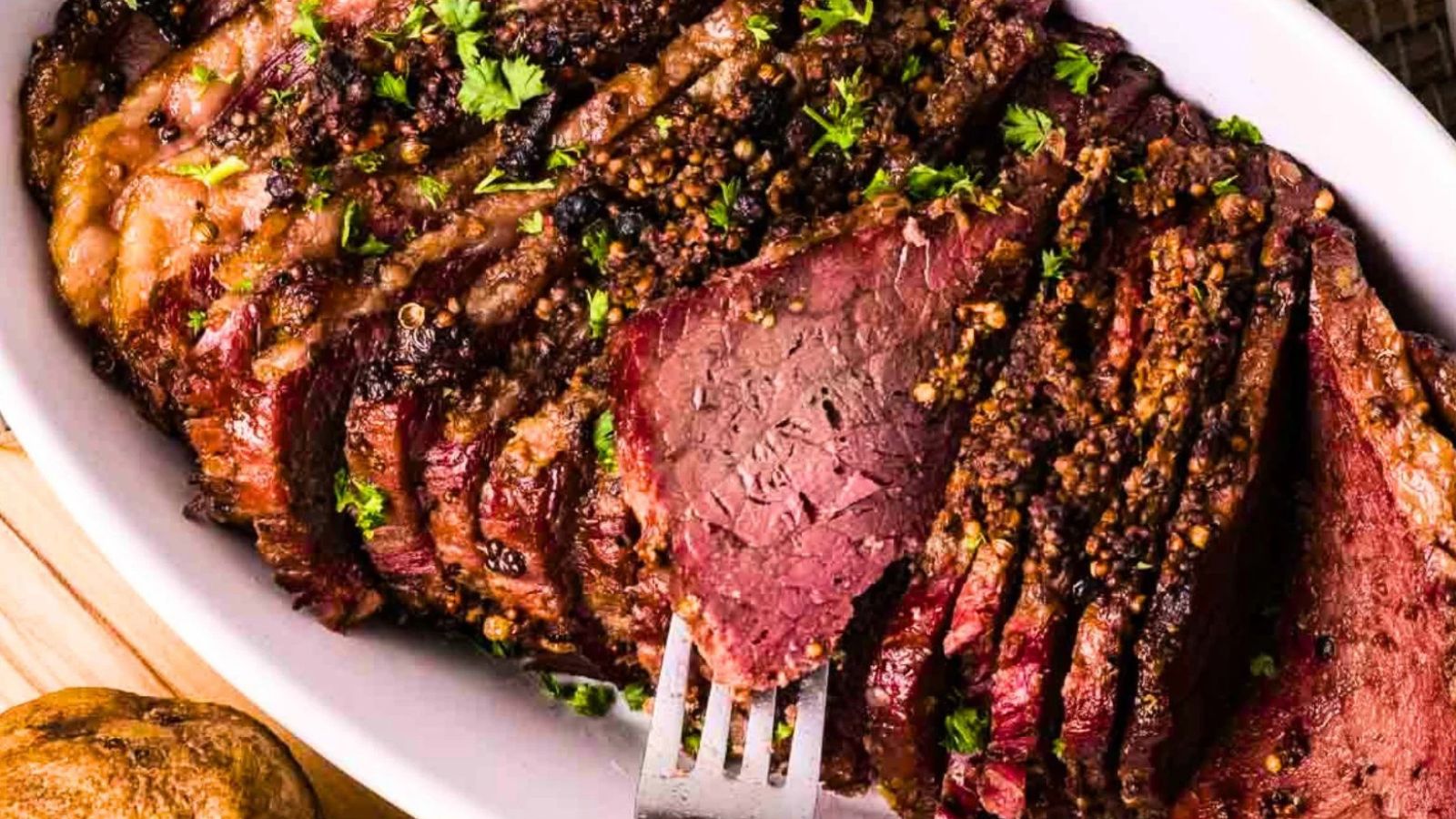 Smoked corned beef sliced showing pink cured interior and dark smoky crust.