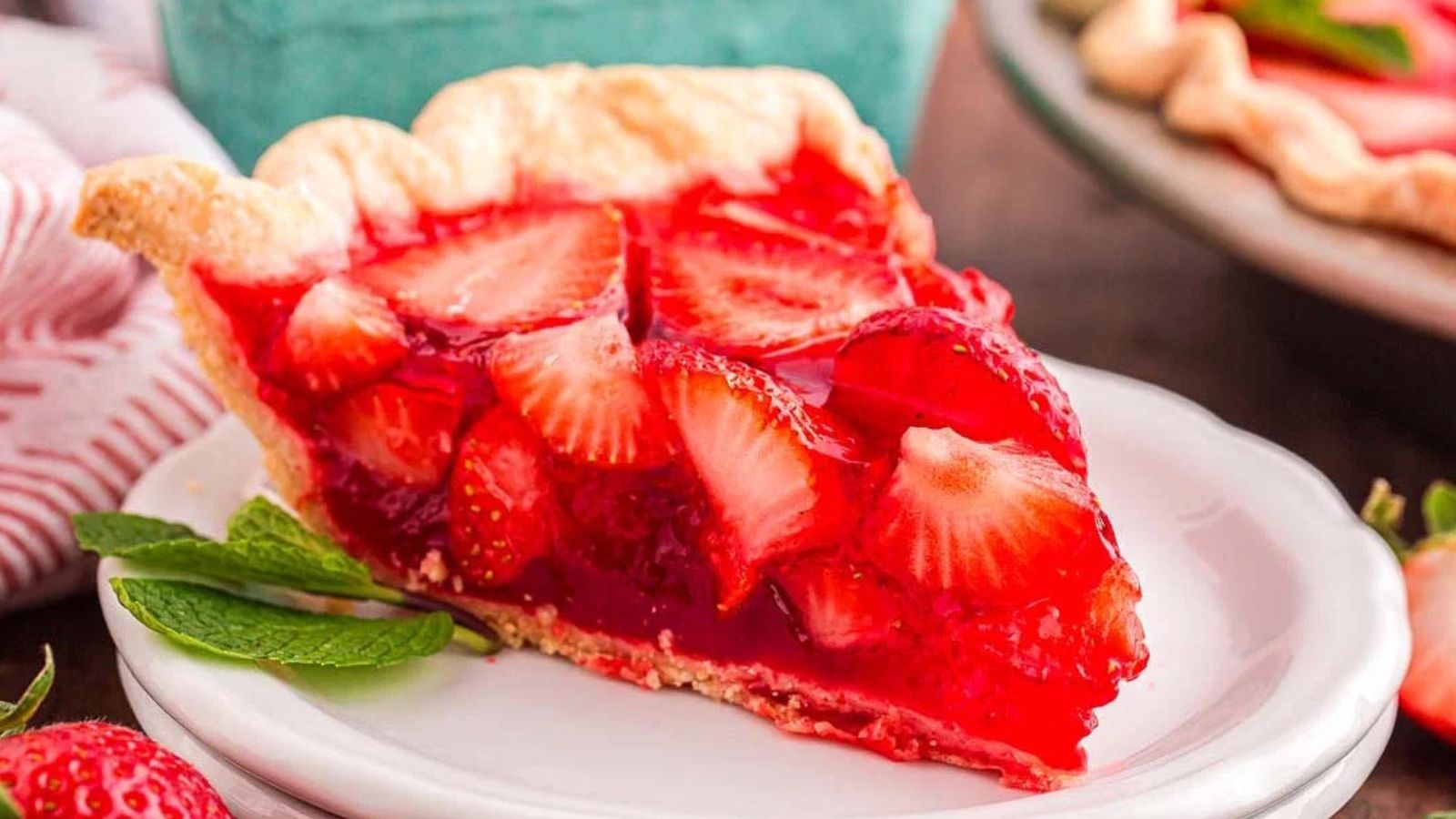 Strawberry pie with a glossy red filling and sliced strawberries arranged on top in a pie crust.