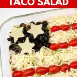 Patriotic taco salad layered with ground beef, cheese, tomatoes, and olives arranged like an American flag.