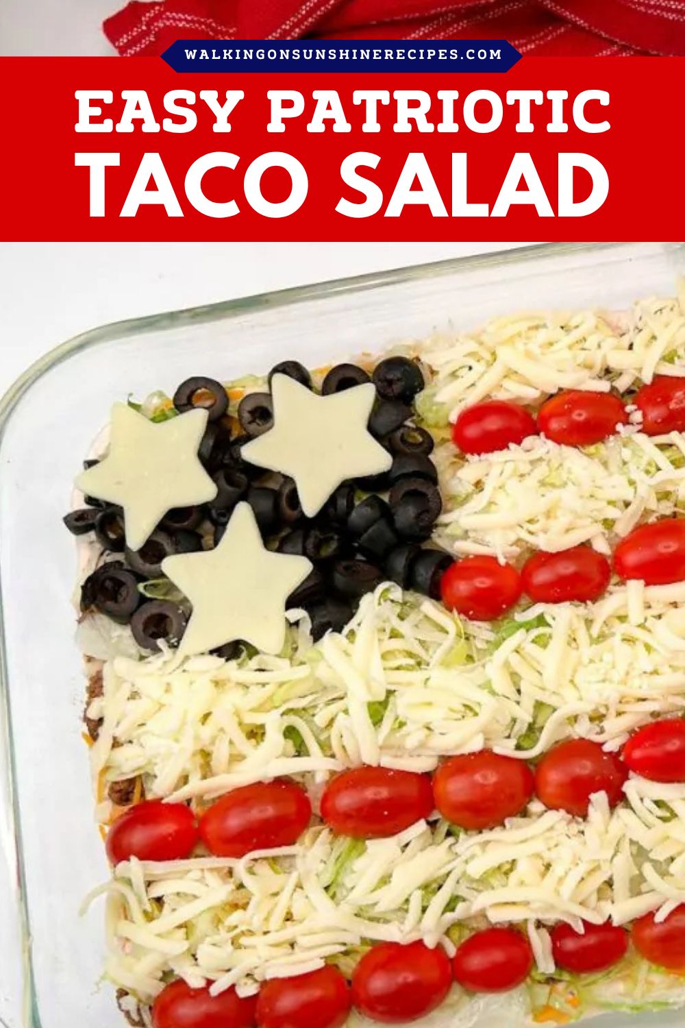 Patriotic taco salad layered with ground beef, cheese, tomatoes, and olives arranged like an American flag.
