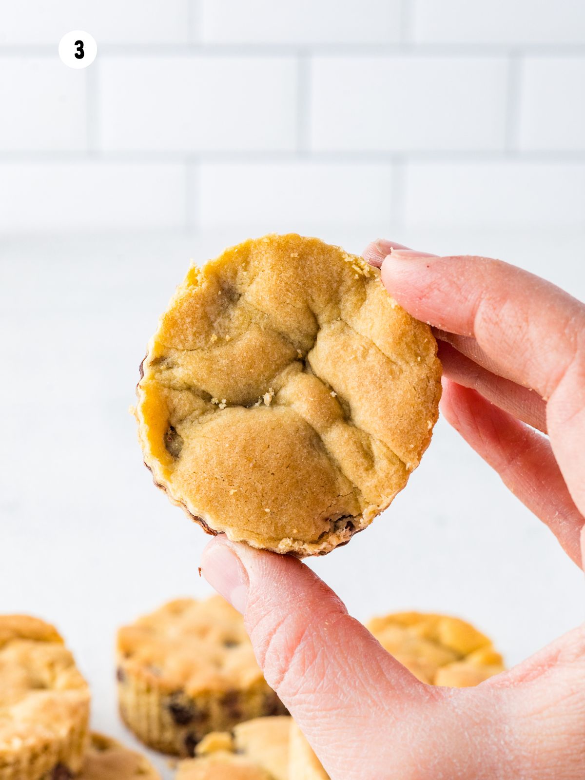 Hand holding a round chocolate chip cake cutout for layering Mason Jar Chocolate Chip Dot Cakes.