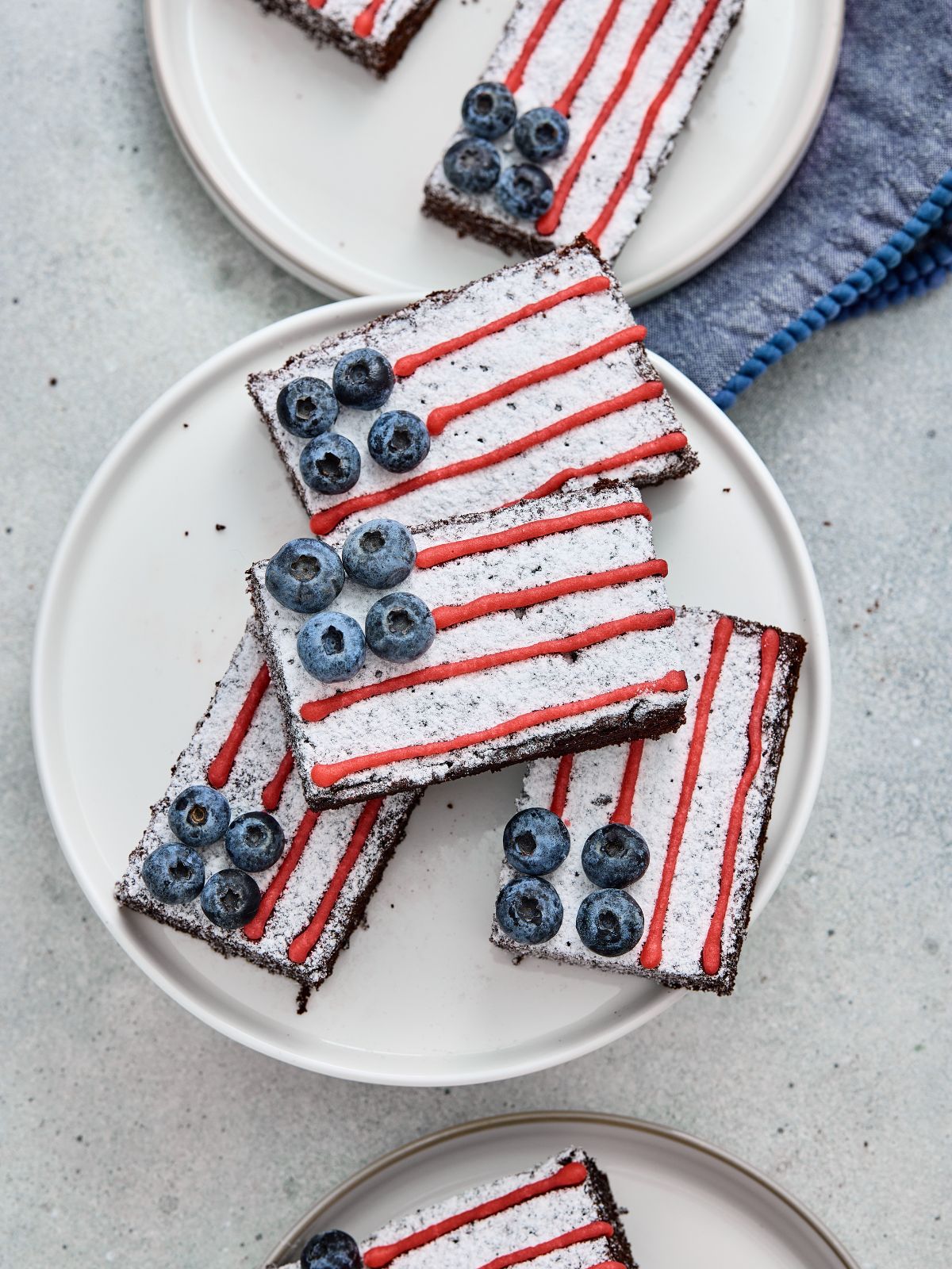 American Flag Brownies decorated with powdered sugar, red icing stripes, and fresh blueberries for an easy 4th of July dessert.