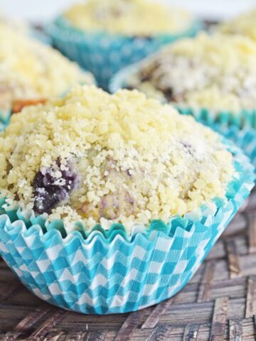 closeup of easy blueberry streusel muffins in blue paper muffin liners.