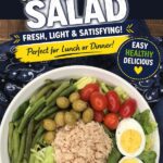 canned tuna salad with potatoes, boiled eggs, olives, grape tomatoes, lettuce, green beans in white bowl.