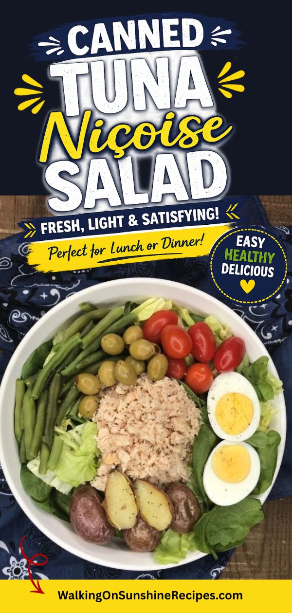 canned tuna salad with potatoes, boiled eggs, olives, grape tomatoes, lettuce, green beans in white bowl.